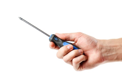 Hand holding shaped blue screwdriver. Close up. Isolated on white background