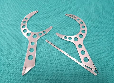 Surgical retractor instrument on table with green background