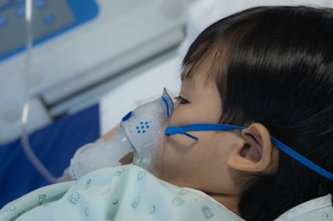 Infant receiving inhalation therapy with mask in hospital