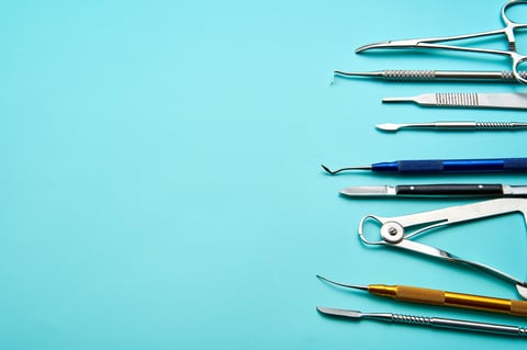 Dental tools arranged on a blue background provide a clean and professional aesthetic, perfect for illustrating dental care or hygiene.
