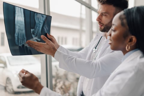 Two doctors examining a foot x-ray, discussing diagnosis and treatment plan