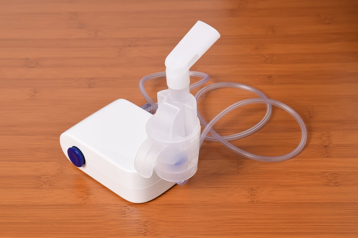 Medical equipment for inhalation therapy for asthma and respiratory diseases. Compressor nebulizer, atomizing cup with mouthpiece isolated