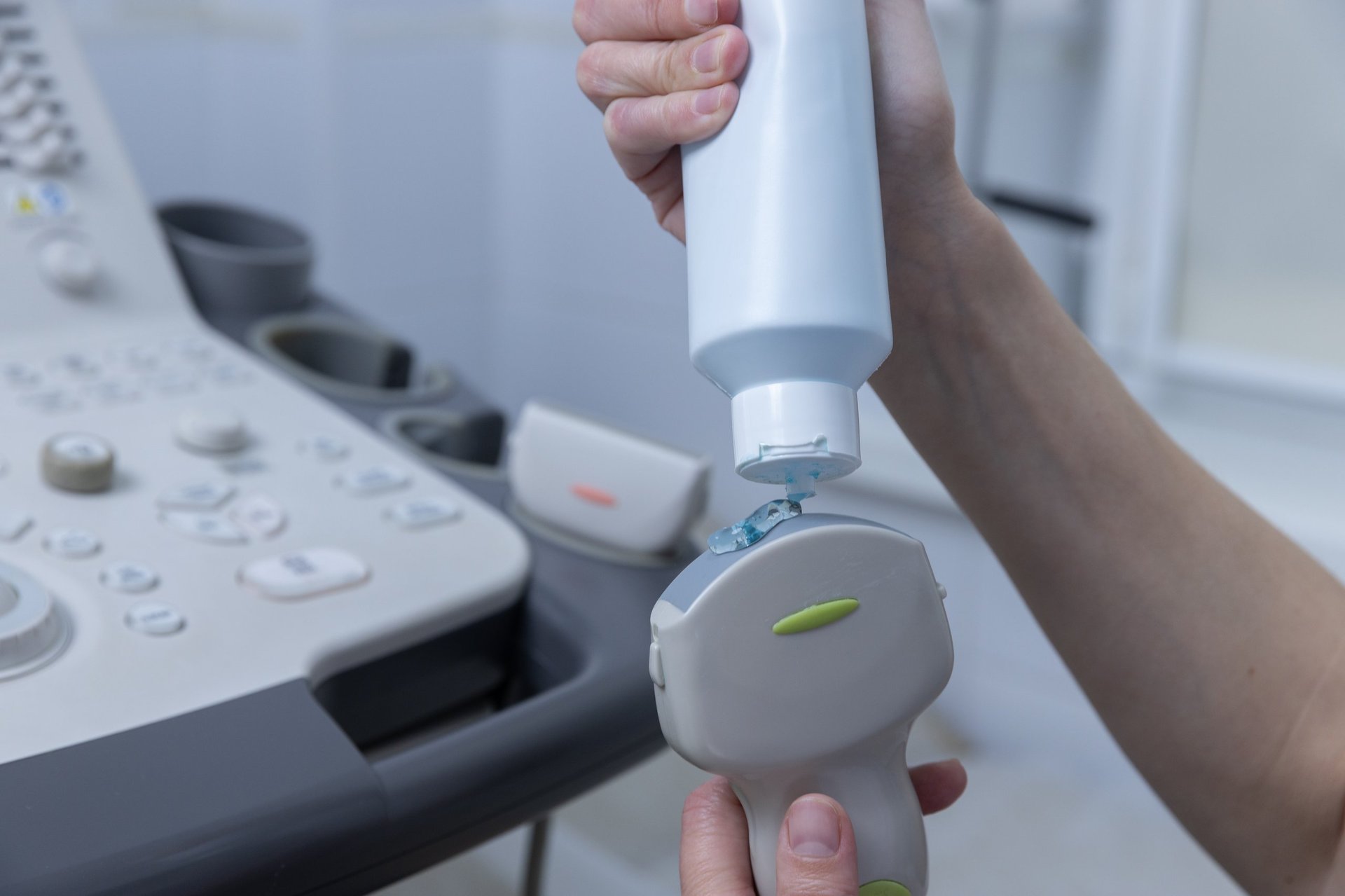 Healthcare professional applying gel to ultrasound transducer