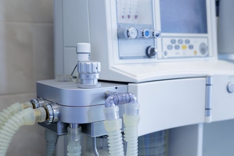 Close view of anesthesia machine breathing circuit and controls in a bright hospital setting