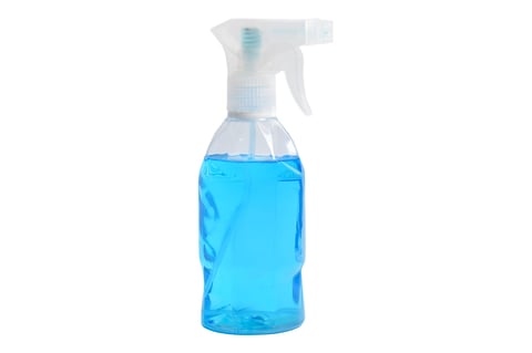 Blue cleaning spray in clear bottle isolated on white background