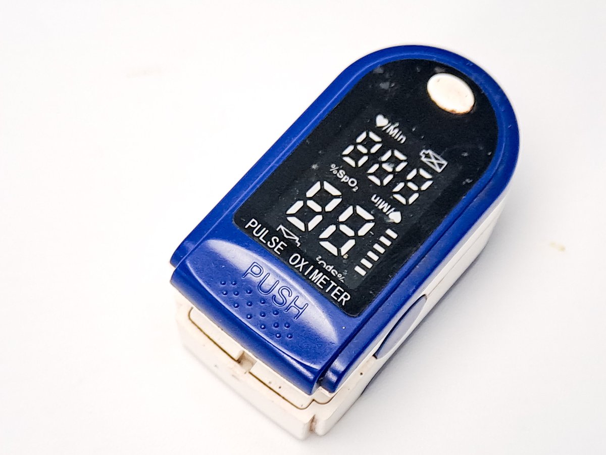 A blue and white digital pulse oximeter, used for quick health checks. Measuring blood oxygen saturation (SpO2) and pulse rate to monitor respiratory and cardiovascular health at home.
