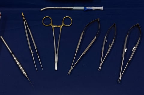 Staindless surgical instruments used in surgery are placed on a blue background