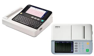 Two medical devices: a white ECG machine with keyboard on the left and a Mindray vital signs monitor with display screen and control buttons on the right