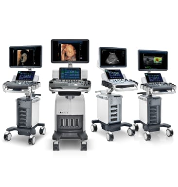 Four medical ultrasound machines displayed in a row, each with monitors showing different ultrasound imaging capabilities on wheeled mobile carts