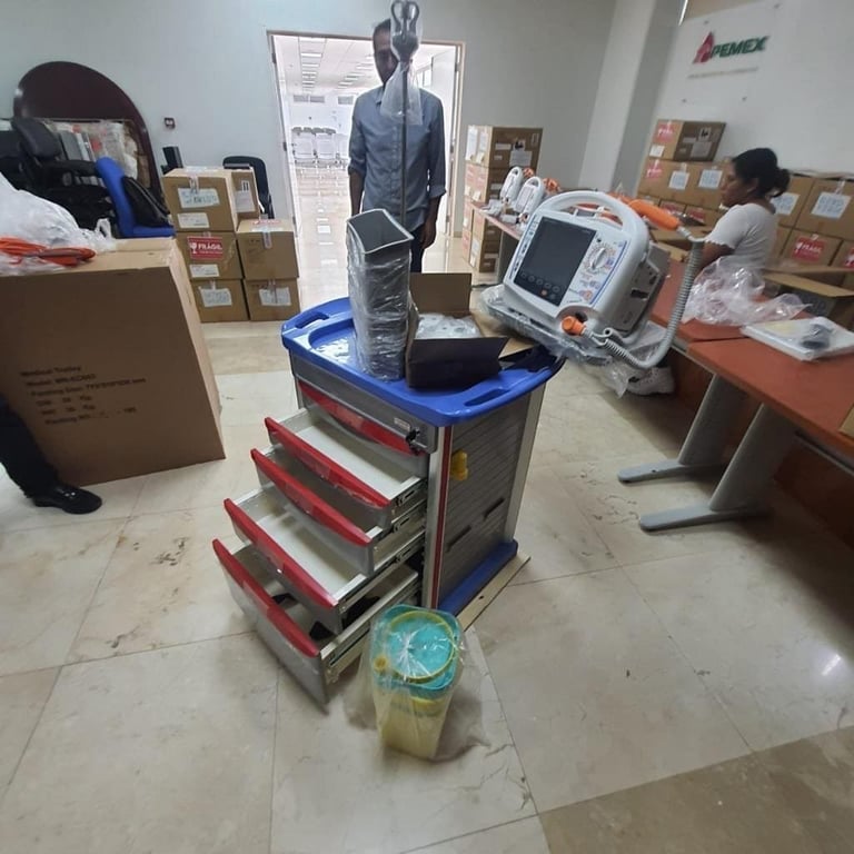 Tool cart with red drawers and blue top in warehouse with cardboard boxes, equipment, and a bottle of liquid