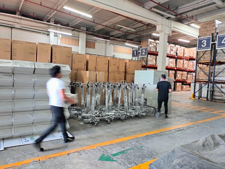 Warehouse workers organizing stacked cardboard boxes and metal racks in an industrial storage facility with numbered shelving units