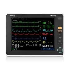 Portable patient monitor displaying vital signs including heart rate, blood pressure, oxygen saturation, and waveforms with green and blue graph lines on screen