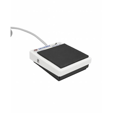 White and black foot pedal control device with gray curved cable attached