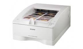 White Sony printer with open top tray containing photo prints