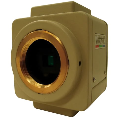 Tan-colored industrial thermal imaging camera with brass lens and black aperture opening