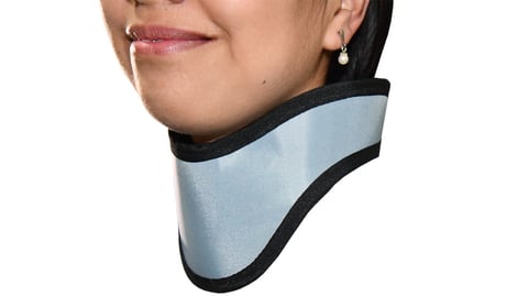 Woman wearing a light blue and black cervical collar neck brace on white background