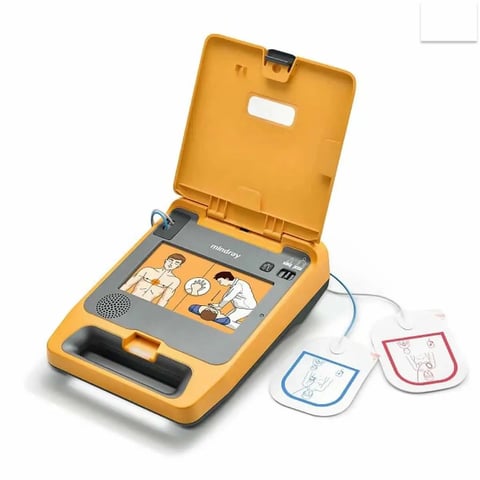 Yellow automated external defibrillator (AED) with electrode pads, displaying usage instructions