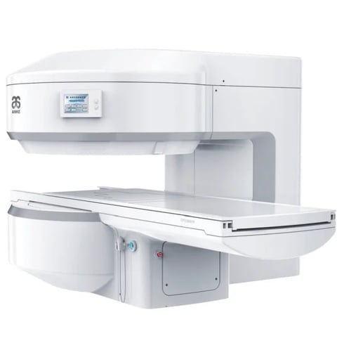 White medical imaging machine, likely an MRI or CT scanner, with open gantry design and extended examination table