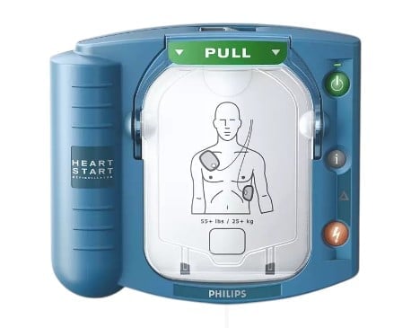 Philips HeartStart defibrillator with blue casing, display showing electrode pad placement diagram, and pull access handle on top