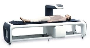 Person lying on a modern spinal decompression or traction therapy table with adjustable mechanical components
