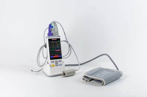 Portable pulse oximetry device with digital display and attached sensor probe on white background